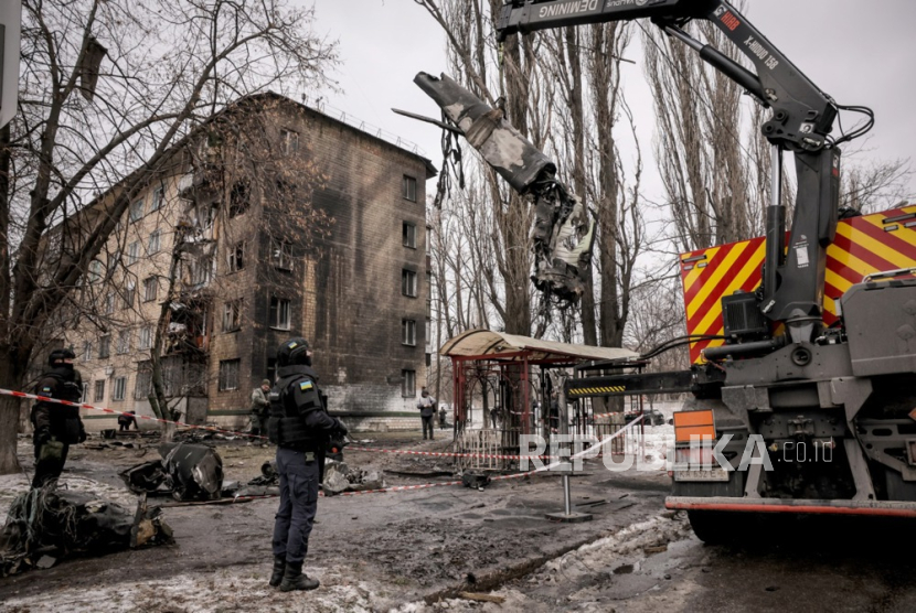 Petugas Layanan Darurat Negara Ukraina membersihkan puing-puing rudal X-101 Rusia yang ditembak jatuh dari lokasi serangan roket, di Kiev, Ukraina, (23/1/2024). 