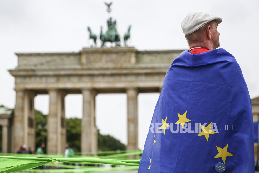  Pendukung Uni Eropa yang dibalut bendera Uni Eropa terlihat di depan Gerbang Brandenburg di Berlin, Jerman, 1 Juli 2020.