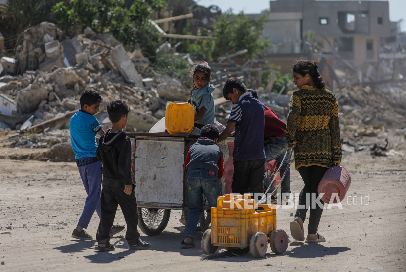 Anak-anak pengungsi Palestina berjalan untuk mengisi tabung air setelah kembali ke kota Khan Younis, Jalur Gaza selatan, 8 Mei 2024.