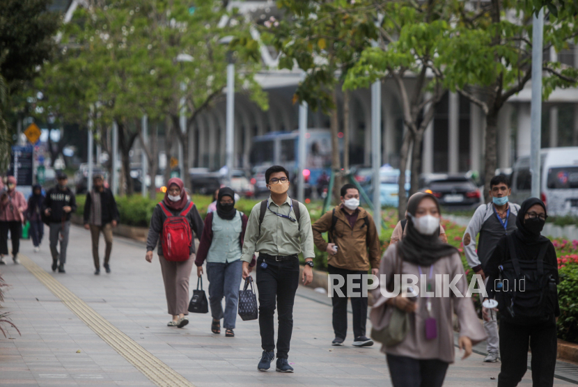Pekerja berjalan saat jam pulang kerja di kawasan Sudirman, Jakarta, Selasa (21/11/2023).
