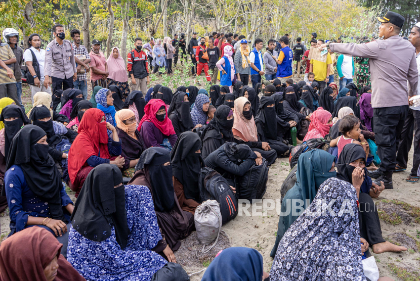 File foto Personel Polri mengawal imigran etnis Rohingya yang terdampar di pantai di kawasan Gampong Baro, Kecamatan Baitussalam, Kabupaten Aceh Besar, Aceh, 8  Januari 2023). 