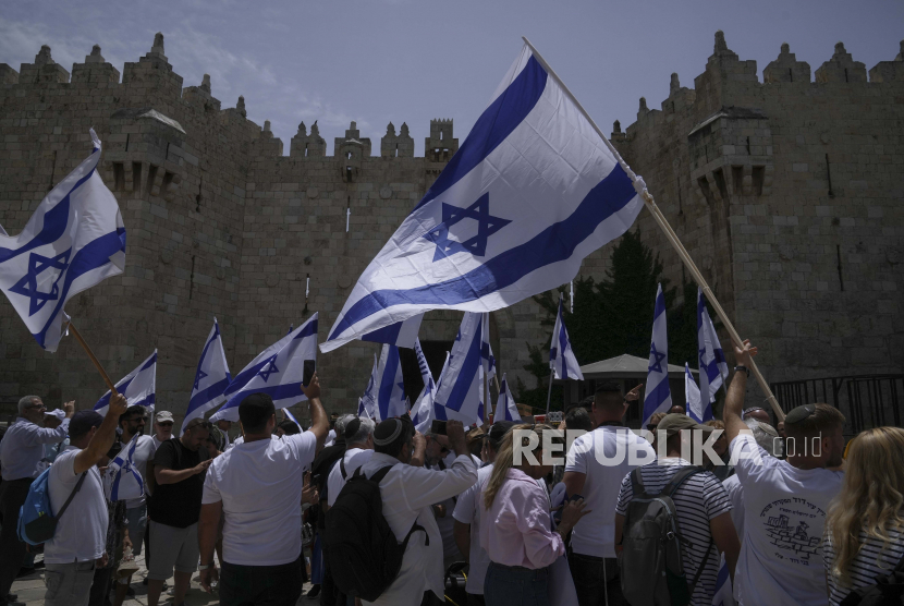 Warga mengibarkan bendera Israel.