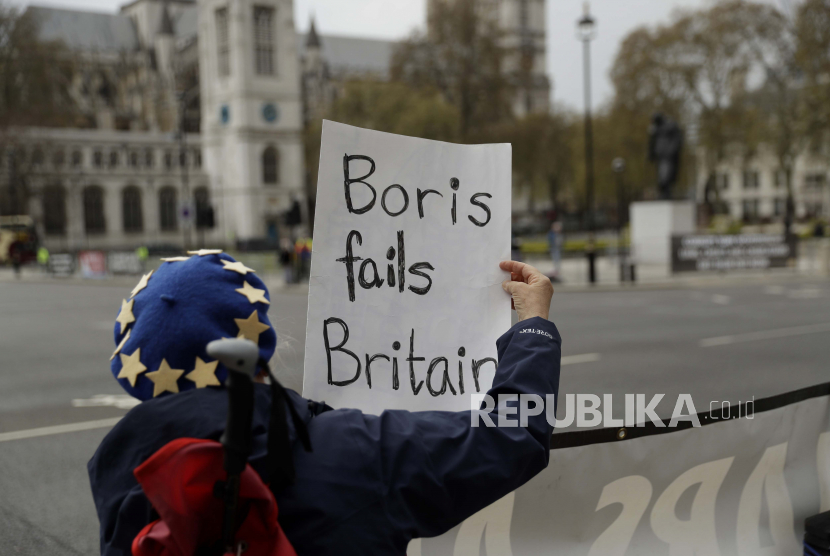 Seorang pengunjuk rasa anti-Brexit memegang plakat setelah Perdana Menteri Inggris Boris Johnson melewati untuk menghadiri Pertanyaan Perdana Menteri di Rumah Parliamet, di London, Rabu, 28 April 2021.  Inggris akan menetapkan rencana yang tumpang tindih dengan sejumlah peraturan perdagangan di Irlandia Utara yang ditetapkan usai Brexit. 