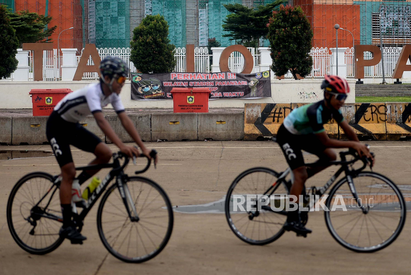 Warga dengan menggunakan sepeda meninggalkan Stadion Pakansari, Kabupaten Bogor, Jawa Barat.