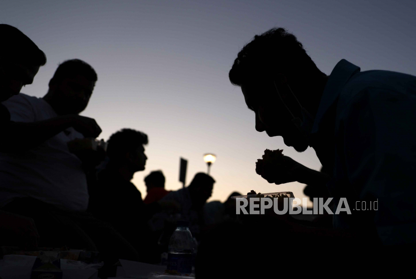  Umat Muslim berbuka puasa setelah matahari terbenam pada bulan suci Ramadhan, di luar Masjid Al Farooq di Teluk Emirat Dubai, Uni Emirat Arab, Selasa (4/4/2023). UEA Sumbangkan Lima Juta Makanan Selama Ramadhan