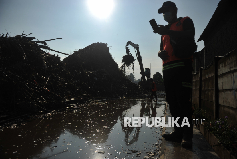 Petugas mengoperasikan alat berat untuk mengangkat sampah di Saringan Sampah TB Simatupang (SSTBS) Jakarta, Senin (3/3/2025). Tumpukan sampah kiriman dari kawasan Bogor tersebut terbawa arus hingga mengalir ke Kali Ciliwung akibat hujan deras di kawasan Bogor pada Ahad (2/3) malam. Dinas Lingkungan Hidup DKI Jakarta telah mengangkut sampah di lokasi tersebut sebanyak lebih dari 1.500 ton sejak pukul 02.00 WIB dini hari hingga saat ini. Tumpukan sampah didominasi oleh ranting dan dahan pohon. Dibutuhkan sebanyak 50 truk sampah untuk memindahkan sampah ke TPST Bantargebang.