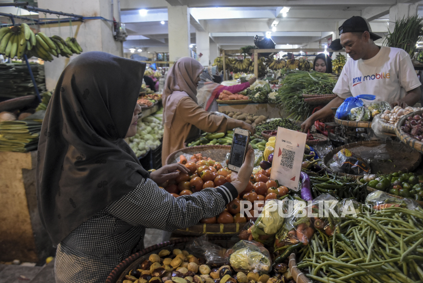 Warga melakukan pembayaran digital di Pasar Tagog Padalarang, Kabupaten Bandung Barat, Jawa Barat, Selasa (7/3/2023).