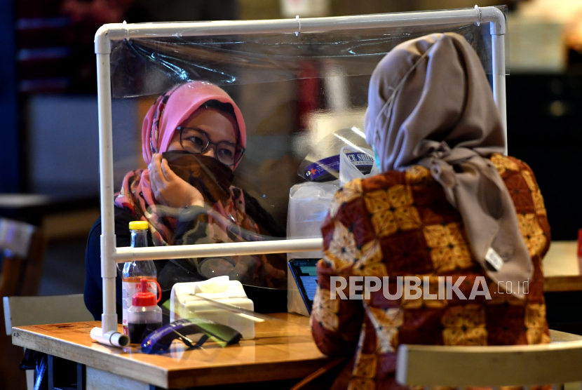 Pelanggan menunggu makanan pesanannya di salah satu restoran di Plaza Marina, Surabaya, Jawa Timur, Selasa (16/6/2020). Sejumlah restoran dan rumah makan di Surabaya mulai membuka layanan makan di tempat dengan protokol kesehatan ketat setelah penerapan Pembatasan Sosial Berskala Besar (PSBB) di wilayah itu memasuki masa transisi  menuju era normal baru