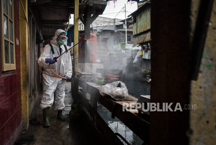 Petugas Palang Merah Indonesia (PMI) Jakarta Pusat menyemprotkan cairan disinfektan di pemukiman Kebon Melati, Jakpus.