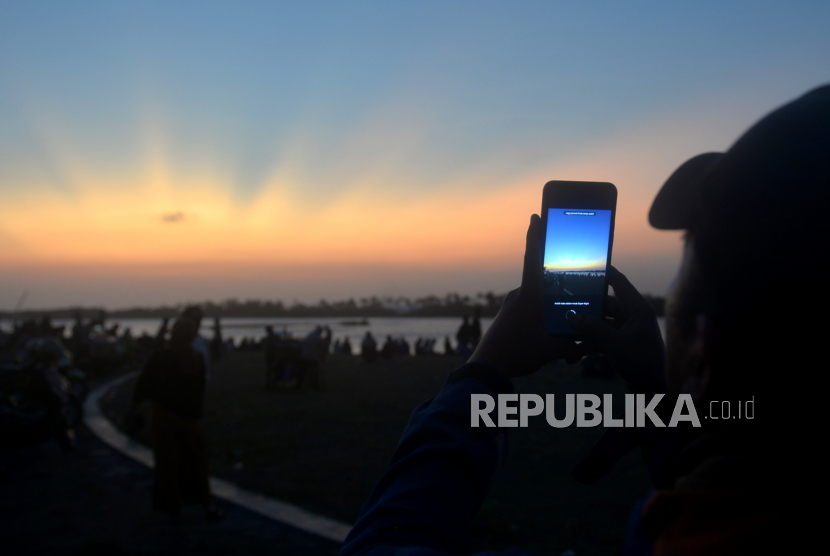 Warga mengambil vidio dengan gawai saat senja di kawasan Laguna Depok, Bantul, Yogyakarta.