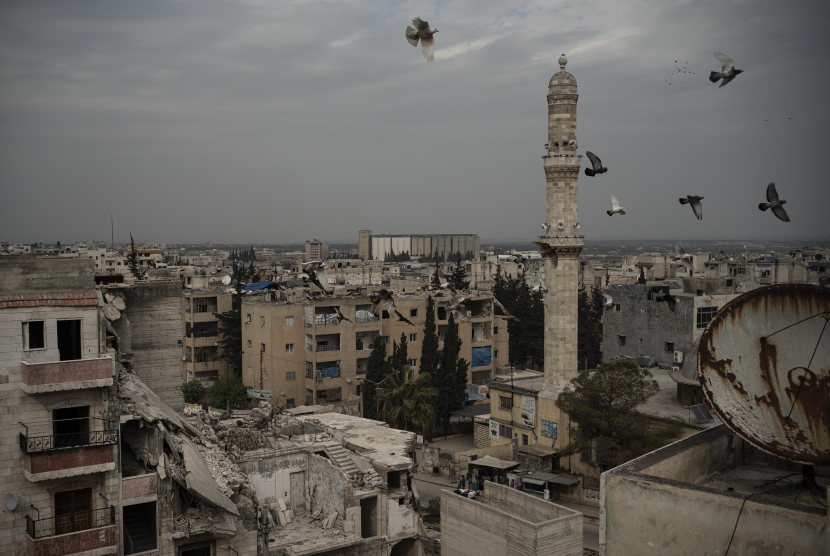 Sebuah masjid berada diantara reruntuhan gedung yang hancur akibat serangan udara di kota Idlib, Suriah. (AP Photo/Felipe Dana)