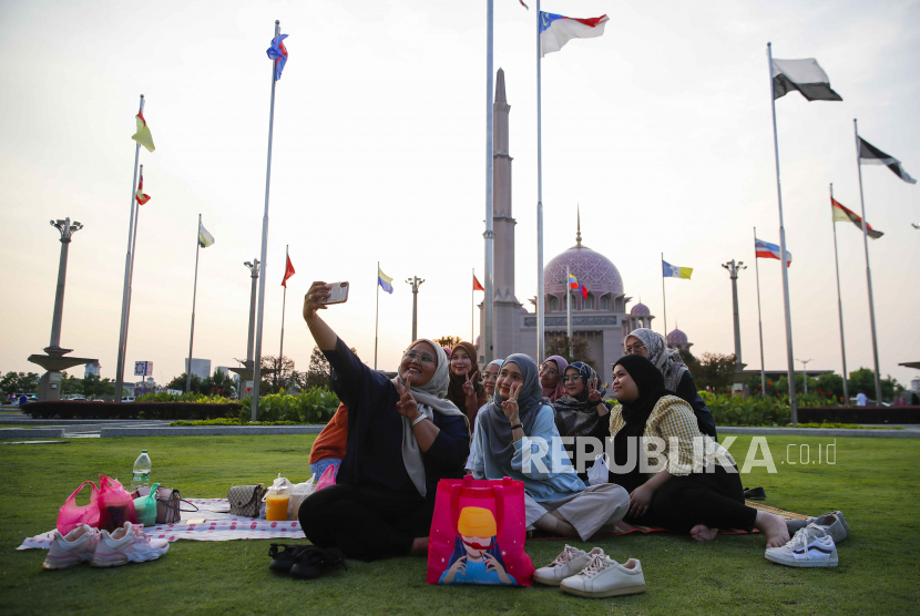  Umat Muslim Malaysia berswafoto sebelum berbuka puasa di bulan Ramadhan di depan Masjid Putra di Putrajaya, Malaysia, Senin (10/4/2023).