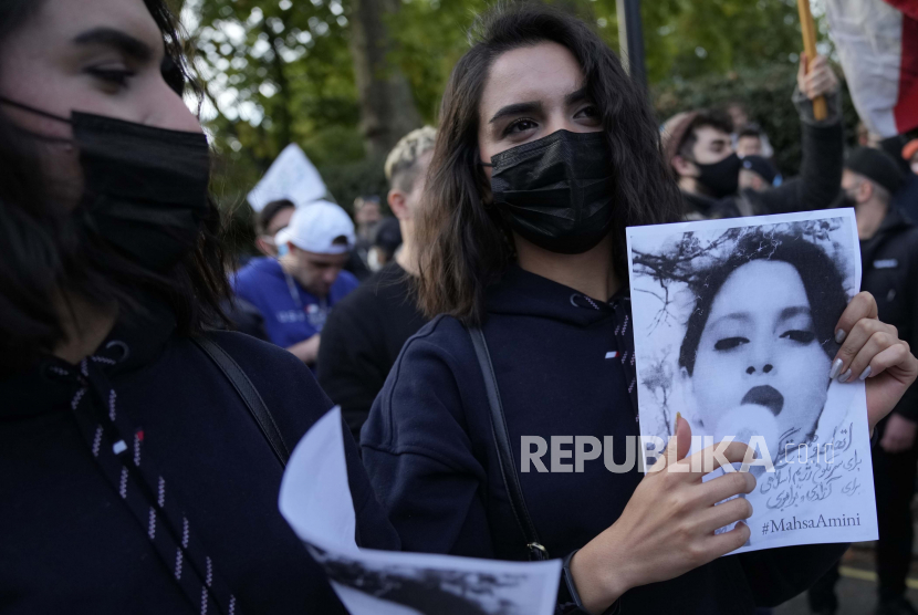 Demonstran memegang plakat di luar Kedutaan Besar Iran di London, Minggu, 25 September 2022. Mereka memprotes kematian Mahsa Amini Iran, seorang wanita berusia 22 tahun yang meninggal di Iran saat dalam tahanan polisi, yang ditangkap oleh Iran polisi moral karena diduga melanggar aturan berpakaian yang diberlakukan secara ketat.
