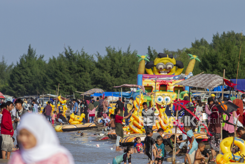 Wisatawan memadati wahana bermain di Pantai Tanjung Pakis, Pakisjaya, Karawang, Jawa Barat, Senin (1/6/2020).  Meski penerapan Pembatasan Sosial Berskala Besar (PSBB) Kabupaten Karawang masih diperpanjang hingga 14 Juni 2020, namun masyarakat sudah memadati lokasi wisata yang berada di Pantai Tanjung Pakis Karawang