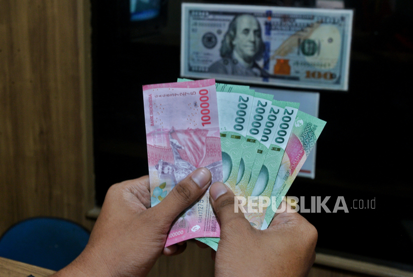 Warga menukarkan uang rupiah terhadap uang dolar AS di konter penukaran uang di Jakarta, Rabu (17/4/2024). 