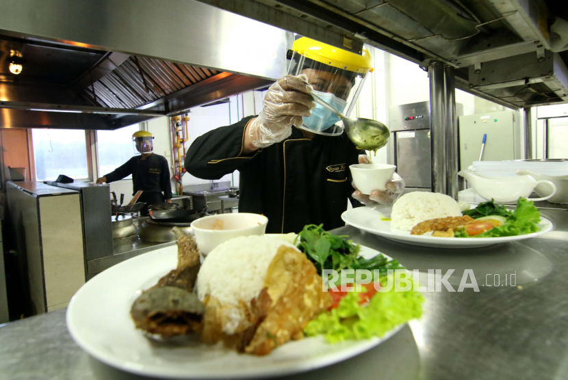 Koki menyiapakan makanan dengan mengenakan Alat Pelindung Diri (APD) di salah satu hotel di Banyuwangi, Jawa Timur.