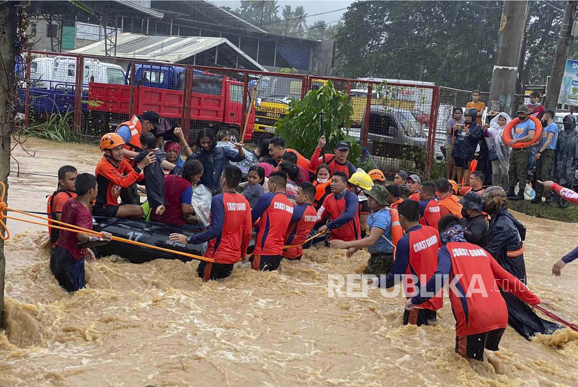 Dalam foto yang dibagikan oleh Penjaga Pantai Filipina ini, tim penyelamat membantu warga di atas banjir yang disebabkan oleh Topan Rai saat mereka dievakuasi ke tempat yang lebih tinggi di Kota Cagayan de Oro, Filipina selatan, Kamis, 16 Desember 2021. 