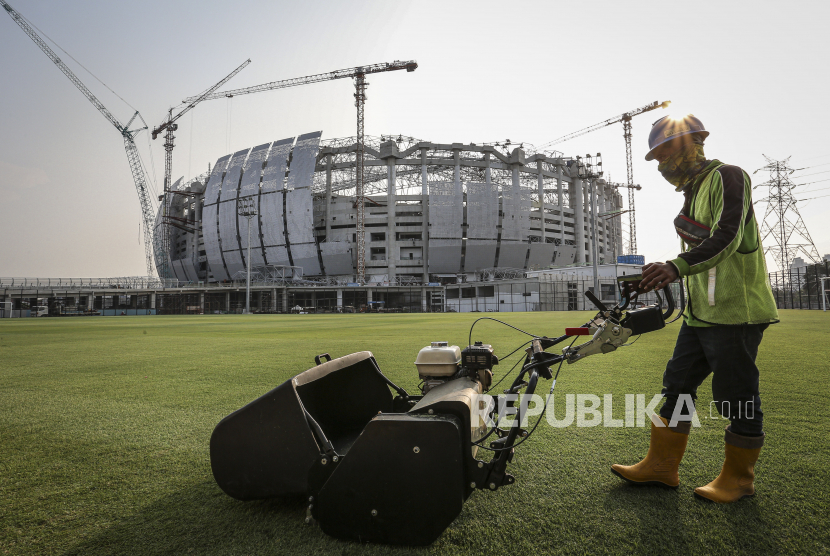 Pekerja memotong rumput lapangan latihan di kawasan Jakarta International Stadium (JIS), Tanjung Priok, Jakarta, Selasa (12/10/2021). Progres pembangunan Jakarta International Stadium pada minggu ke-110 mencapai 75,2 persen dan ditargetkan dapat beroperasi akhir tahun 2021. 