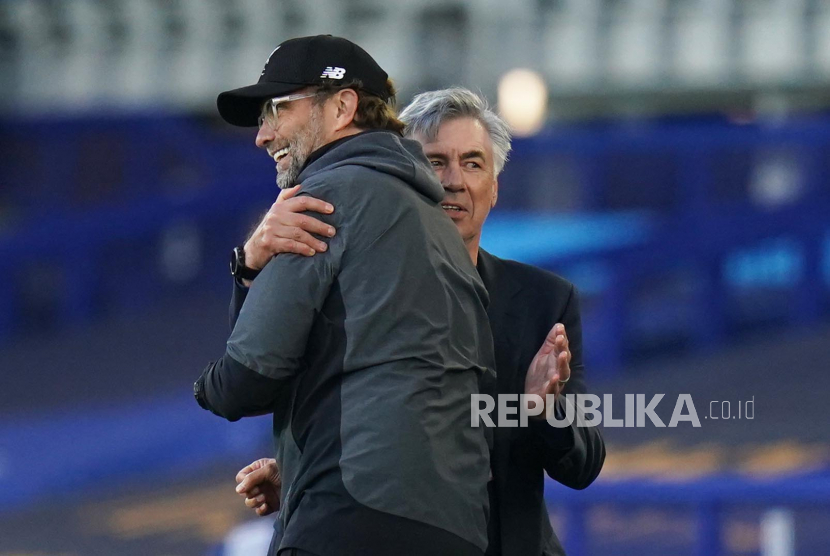 Pelatih Liverpool Jurgen Klopp (kiri) berpelukan dengan Carlo Ancelotti.