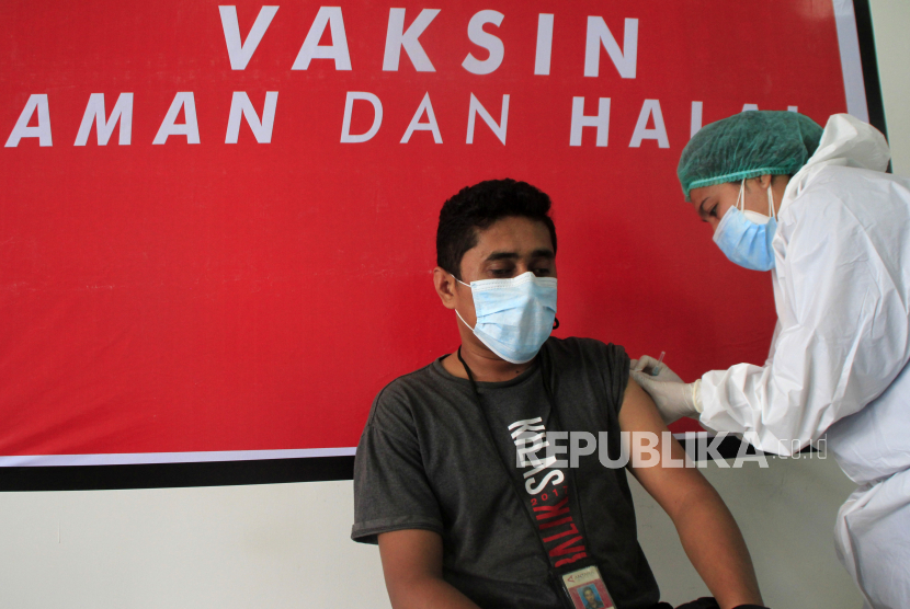 Seorang pewarta menerima suntikan vaksin.