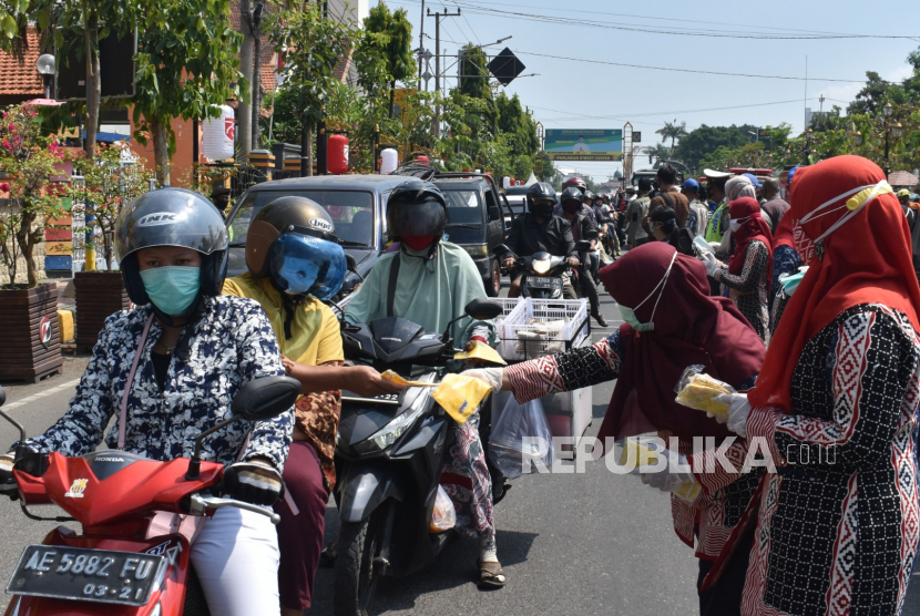 Relawan membagikan masker kepada pengendara saat Kampanye Penggunaan dan Pembagian Masker Serentak di Kota Madiun, Jawa Timur, Kamis (10/9/2020). Pemkot Madiun bersama TNI, Polri, Ormas dan relawan membagikan 10 ribu masker kepada masyarakat di sejulah lokasi guna pencegahan penularan COVID-19. 