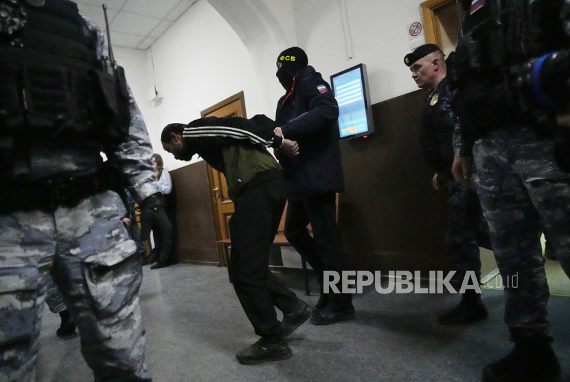 Shamsidin Fariduni, tersangka penembakan Balai Kota Crocus pada Jumat dikawal petugas FSB di Pengadilan Negeri Basmanny di Moskow, Rusia, Senin (25/3/2023) dini hari WIB.