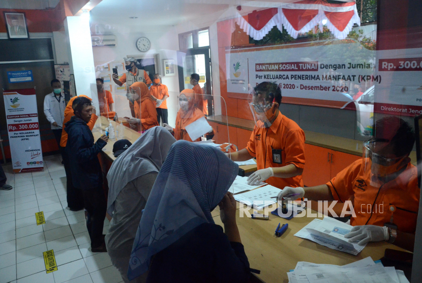 Kesibukan petugas melayani penerima bantuan saat Penyaluran Batuan Sosial Tunai (BST), di Kantor Pos, Jalan PHH Mustofa, Kota Bandung, Rabu (5/8). BST dengan jumlah Rp 300.000 itu diberikan kepada Keluarga Penerima Manfaat (KPM). 