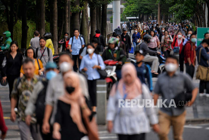 Pekerja berjalan di pedestrian kawasan perkantoran Sudirman, Jakarta, Selasa (2/5/2023). Badan Perencanaan Pembangunan Nasional (Bappenas) menyebut pertumbuhan ekonomi sebesar lima persen tidak mampu mengeluarkan Indonesia dari jebakan pendapatan kelas menengah.