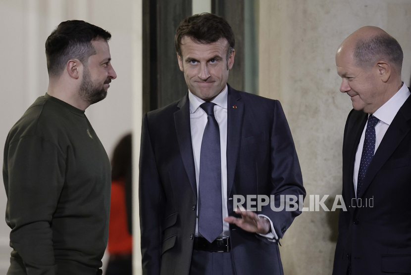  Presiden Prancis Emmanuel Macron (tengah) berfoto bersama Presiden Ukraina Volodymyr Zelenskyy (kiri) dan Kanselir Jerman Olaf Scholz, di depan jamuan makan malam di Istana Elysee, Paris, Rabu (8/2/2023).