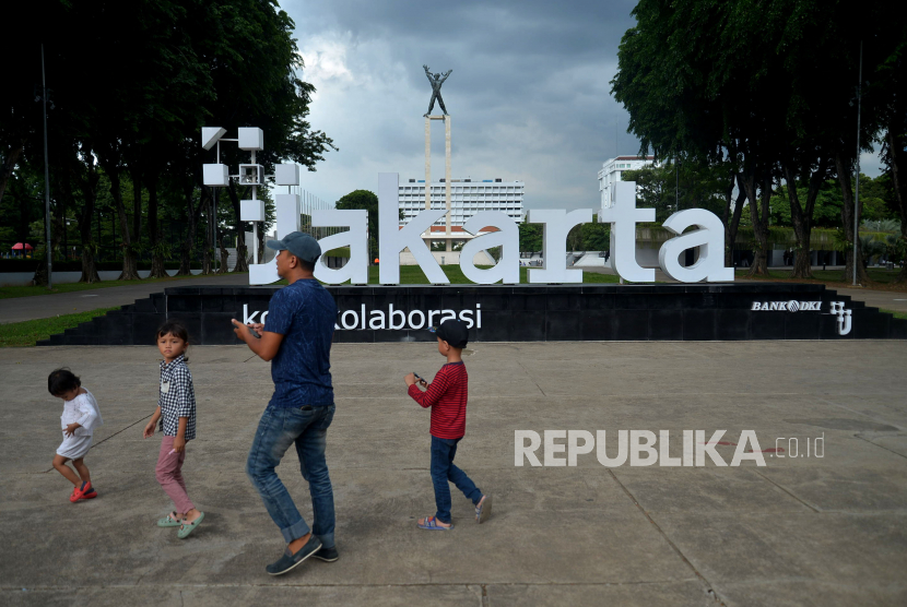 Warga melitas di dekat instlasi logo PlusJakarta dengan slogan Kota Kolaborasi di Taman Lapangan Banteng, Jakarta, Senin (12/12/2022). Pj Gubernur Heru Budi menilai wajar saja dalam mengganti logo dan slogan DKI Jakarta.
