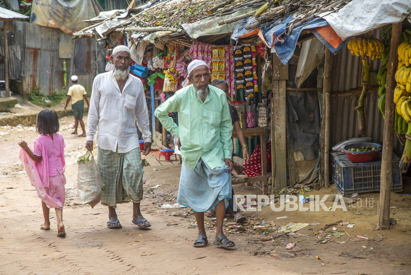 Pengungsi Rohingya berjalan di jalan sepanjang kamp darurat di Kutubpalang, distrik Ukhiya Cox Bazar, Bangladesh, 24 Agustus 2022. 