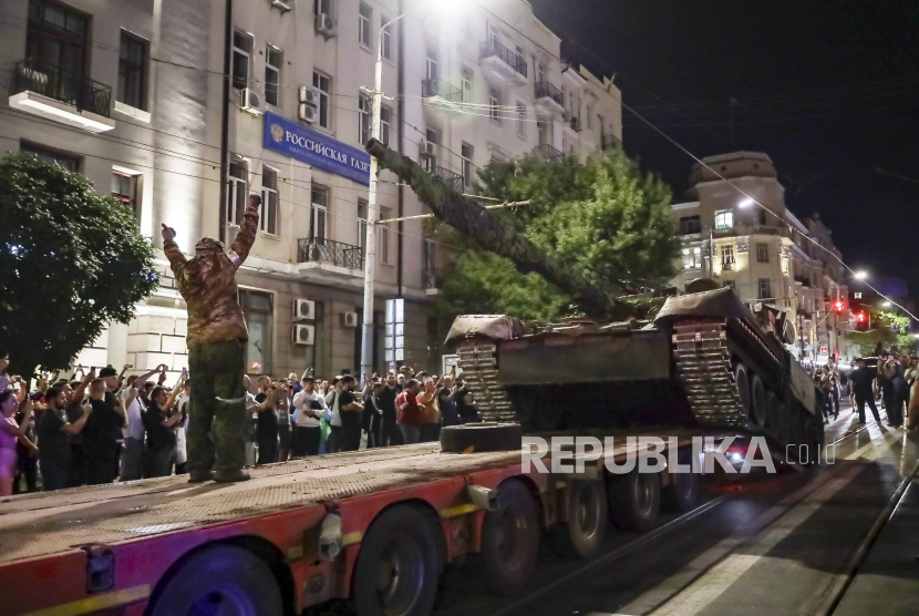 Anggota Wagner menaikkan tank ke sebuah truk di Rostov-on-Don, Rusia, Sabru, 24 Juni 2023, 
