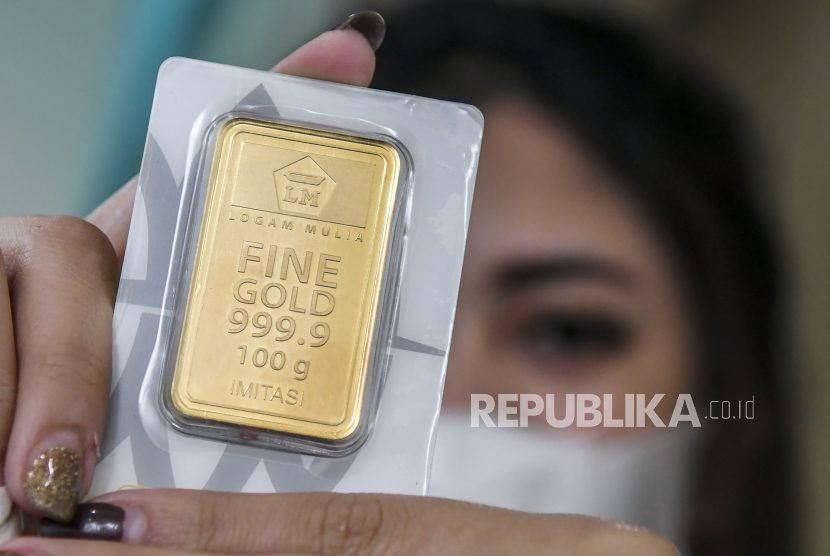 Karyawan menunjukan emas batangan di Butik Emas Antam, Kebon Sirih, Jakarta, Senin (18/1). Harga emas produksi Antam pada Kamis (18/11) diperdagangkan naik jadi Rp 956.000 per gram.