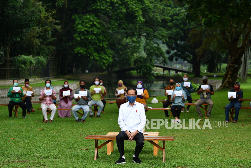 Presiden Joko Widodo berfoto bersama penerima bantuan modal kerja di Istana Bogor, Jawa Barat, Rabu (15/7/2020). Presiden kembali menyerahkan bantuan kepada para pedagang kaki lima, keliling, rumahan hingga pedagang asongan masing-masing sebesar Rp2,4 juta sebagai tambahan modal kerja di tengah kondisi pandemi COVID-19. ANTARA FOTO/Sigid Kurniawan/POOL/foc.