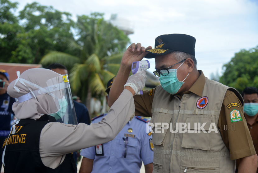 Pelaksana Tugas (Plt) Gubernur Aceh, Nova Iriansyah (kanan) menjalani pemeriksaan suhu. 