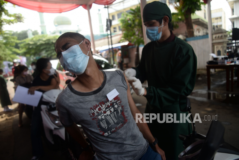 Tenaga kesehatan menyuntikkan vaksin Covid-19 kepada warga secara Drive Thru di Polres Metro Jakarta Selatan, Jakarta, Rabu (30/6).