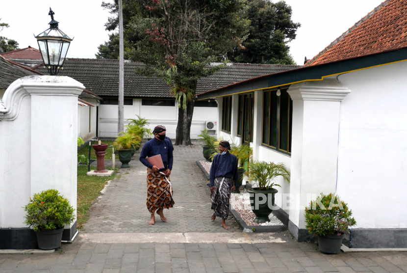 Abdi dalam menggunakan masker berjalan di dalam komplek Keraton Yogyakarta, Selasa (22/9).
