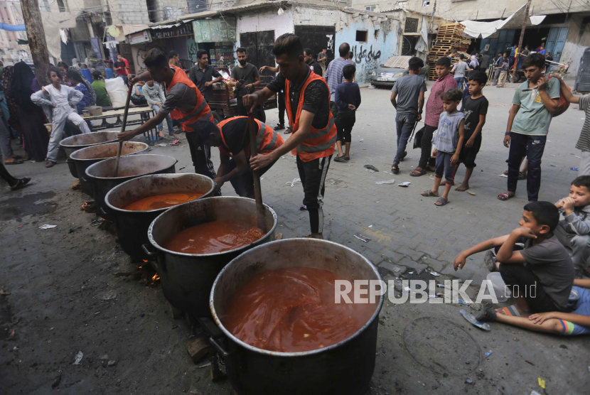 Warga Palestina memasak selama pengeboman Israel yang sedang berlangsung di Jalur Gaza di Rafah pada Senin, 13 November 2023.
