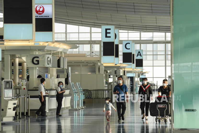 Penumpang berjalan di area keberangkatan di Bandara Internasional Tokyo di Haneda di Tokyo, Jepang (ilustrasi). Jepang akan melonggarkan aturan karantina mandiri dua pekan untuk sebagian pelaku bisnis yang berpergian ke luar negeri.