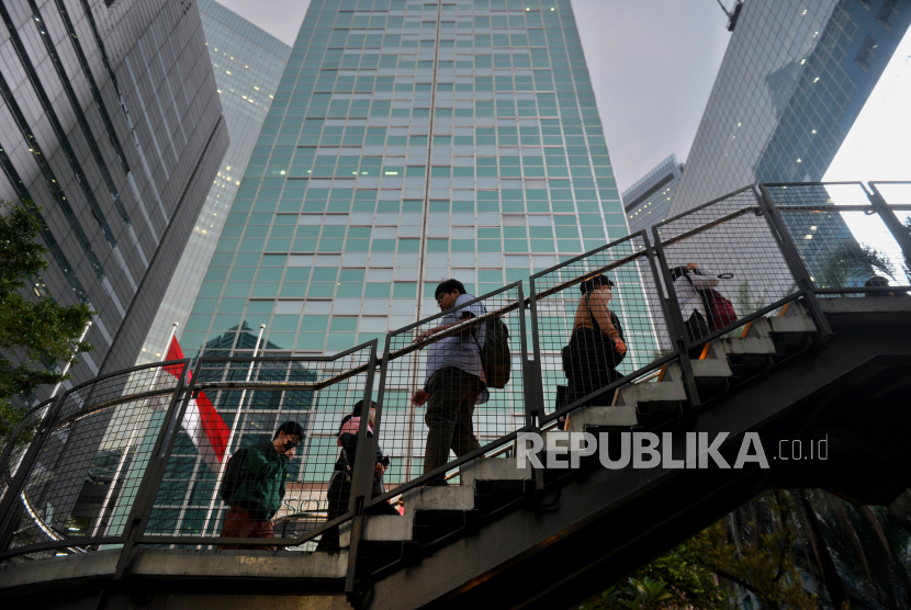 Pekerja berjalan di JPO kawasan perkantoran Sudirman, Jakarta, Selasa (2/5/2023). 
