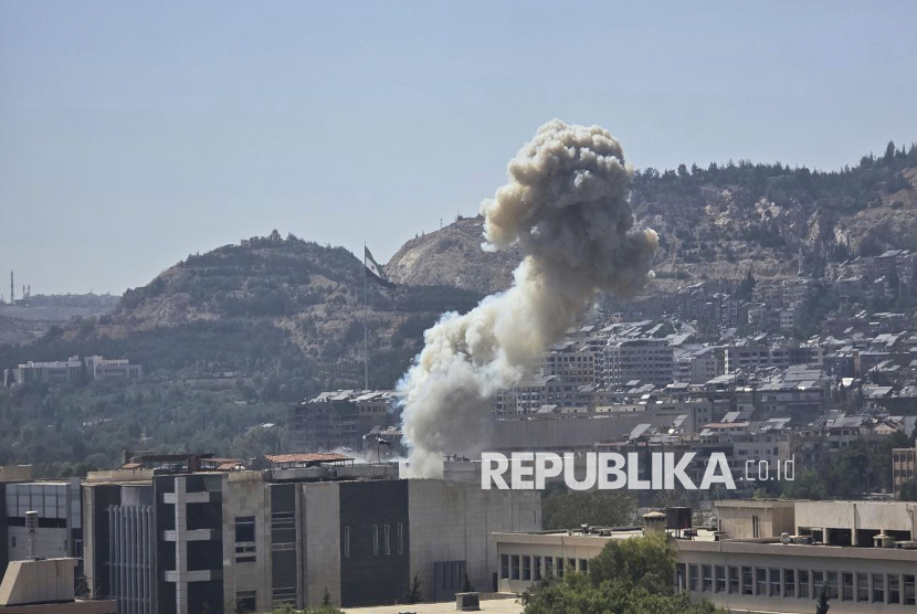 Asap mengepul dari serangan udara Israel yang menghantam Kementerian Pertahanan Suriah di Damaskus, Suriah, Rabu (16/7/2025). Israel melancarkan serangan udara di Damaskus dengan sasaran gedung Staf Umum, Kementerian Pertahanan, dan sekitar istana kepresidenan. Kantor berita pemerintah Suriah, SANA, mengutip Kementerian Kesehatan mengatakan sedikitnya sembilan orang terluka dalam serangan udara Israel.