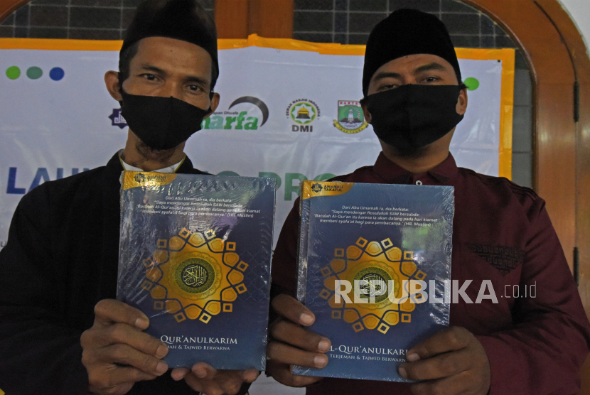 Guru mengaji memperlihatkan Al-Quran saat pencanangan Gerakan Wakaf Al-Quran di Serang, Banten, Sabtu (3/10/2020). Gerakan Wakaf Alquran yang difasilitasi Yayasan Harapan Duafa berhasil mengkordinir pendistribusian 1.000 Al-Quran untuk mesjid dan tempat mengaji di Banten. ANTARA FOTO/Asep Fathulrahman/hp. Dialog Jumat