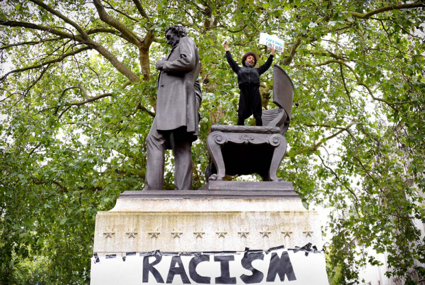Seorang wanita memanjat patung Abraham Lincon di Parliament Square saat aksi Black Lives Matter di London, Sabtu (6/6). Sejumlah massa diseluruh dunia melakukan aksi solidaritas atas kematian George Floyd yang meninggal dalam tahanan polisi di Minneapolis