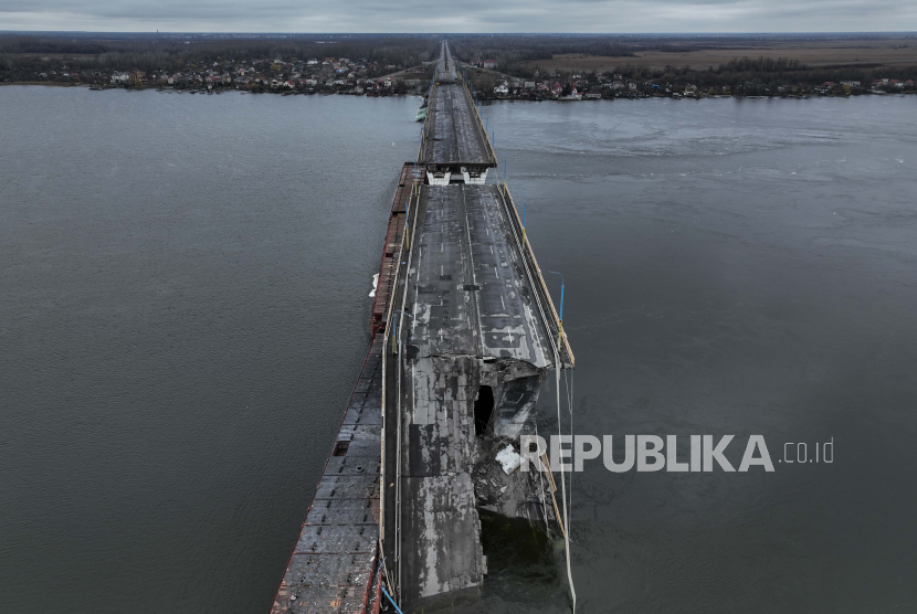 Pemandangan umum Jembatan Antonivsky yang rusak di Kherson, Ukraina, Ahad, 27 November 2022. Jembatan tersebut, titik penyeberangan utama di atas sungai Dnipro di Kherson, dihancurkan oleh pasukan Rusia pada awal November, setelah pasukan Kremlin mundur dari selatan kota.