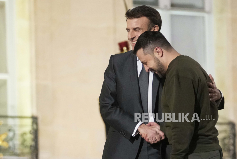  Presiden Ukraina Volodymyr Zelenskyy (kanan) dan Presiden Prancis Emmanuel Macron berjabat tangan sebelum pertemuan bersama mereka dengan Kanselir Jerman Olaf Scholz di Istana Elysee di Paris, Prancis, Rabu (8/2/2023).