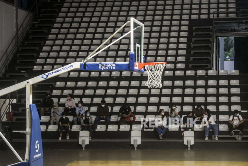 Penonton duduk dengan menjaga jarak pada kegiatan simulasi kehadiran penonton saat pertandingan basket di Hall Basket Senayan, Jakarta, Jumat (7/1). Simulasi kehadiran penonton itu sebagai persiapan jelang kompetisi basket Indonesian Basketball League (IBL) 2022 di Hall Basket yang akan digelar pada 15 Januari mendatang. Republika/Putra M. Akbar