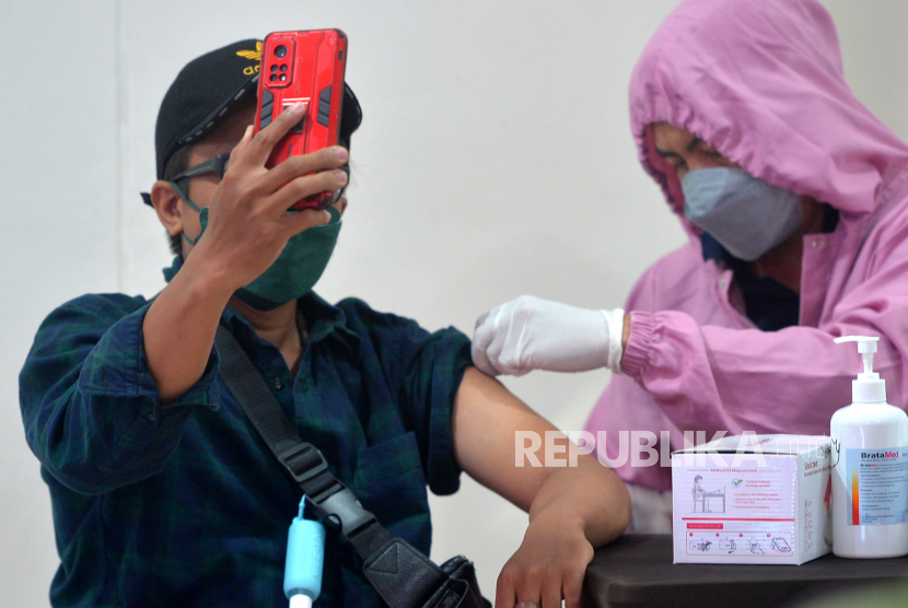 Warga mengikuti vaksinasi Covid-19 booster, ilustrasi. Pemerintah Kota Surabaya mempunyai cara dalam menarik warga agar ikut vaksinasi penguat (booster) dengan memberikan sembako saat vaksinasi di Tanah Kali Kedinding, Kota Pahlawan, Jatim.