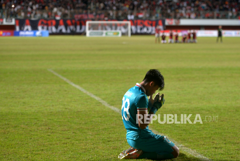 Kiper timnas Indonesia U-16 Andrika Fathir Rachman berdoa saat adu penalti melawan Myanmar U-16 saat pertandingan semifinal AFF U16 Putra 2022 di Stadion Maguwoharjo, Sleman, Yogyakarta, Rabu (10/8/2022). Indonesia mengalahkan Myanmar 5-4 setelah bermain imbang 1-1 pada waktu normal.