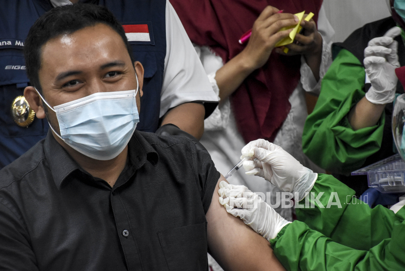 Vaksinator menyuntikkan vaksin Covid-19 Sinovac ke Sekretaris Daerah Kota Bandung Ema Sumarna.