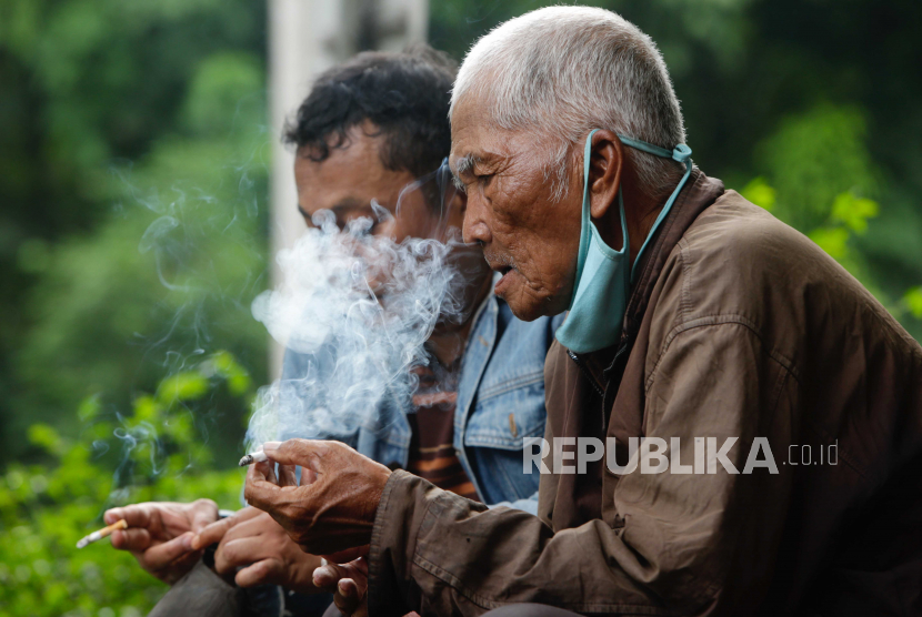 Warga lansia Ahmad (80 tahun) merokok di pinggir jalan protokol di Jakarta, 31 Mei 2021. Ahmad mengaku, merokok sejak berusia 19 tahun.